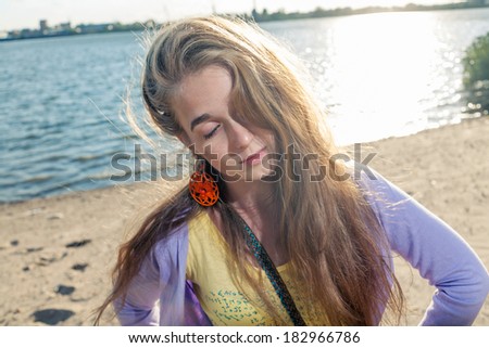 Mysterious girl alone on aseashore with her eyes closed