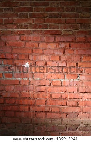 Red brick wall vertical image with vignette of spot of light in a center. Very good as frame for design