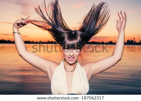 Dancing in water at sunset. Flying hair. Skincare and beauty face. Sensual girl with long healthy hair outdoors.