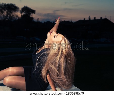 Cute women posing with her pretty long blond hair hanging down