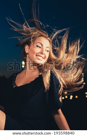 Blond hair fly in a wind. Female smiling outdoors