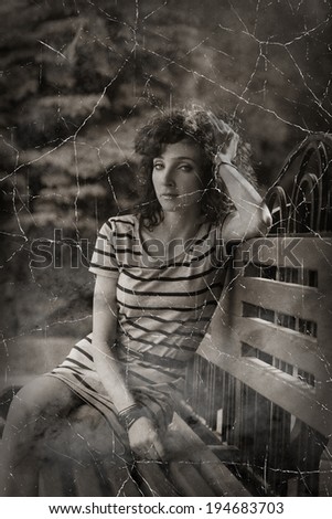 Red haired women sitting on a park bench in a calm state vintage looking photo in sepia colors