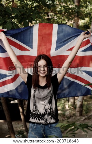 Smiling women with UK flag in her outstretched hands.