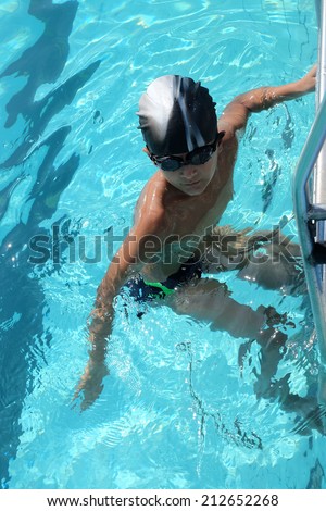 Boy swim in pool with blur transparent water