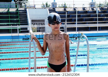 Small boy posing in swimming pool