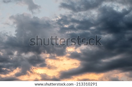 Background of dark clouds with orange spot  before a thunder-storm