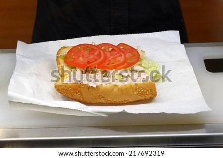 Sandwich with fresh tomatoes  in fast food place