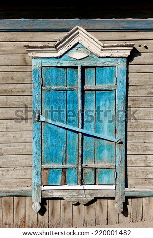 Aged wood window painted in blue colour