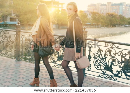 Two girl walking together and one look back