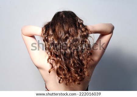 Rear view of the long curly haired women