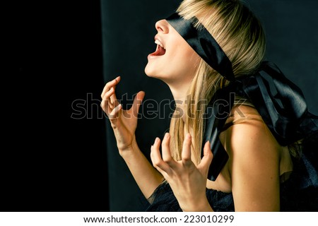 Blindfold women cry and a lot of copyspace, gray and black background with harsh edge