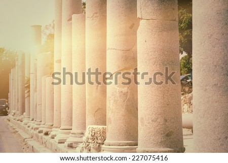 Row of pillars backlit in town Side (Turkey), ancient Roman architecture, ruins of aged castle, religious building in bright sun light, vintage photo