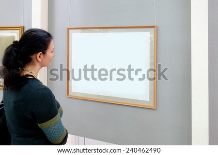 Women looking at modern painting at the art gallery wall/ Blank frame for painting or information.