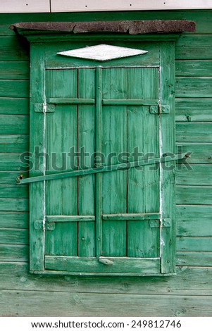 Old wooden window in a wall painte in green color. Astrakhan, Russia.