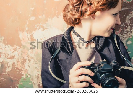 Smiling vintage women with photocamera in her hands, vintage film instagram colors.