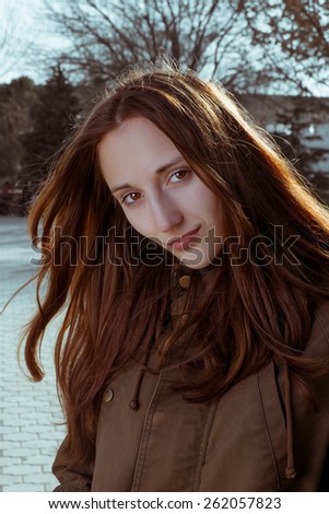 Young girl posing in calm state in city park vertical toned colorized image.