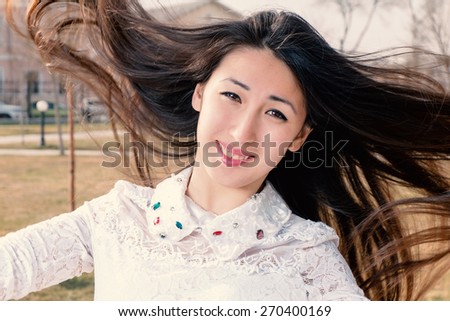 Asian Romantic Girl Outdoors. Beautiful Japanese Model Closeup Portrait. Long Hair Blowing in the Wind. Backlit, Warm Golden Color Tones Instagram Look