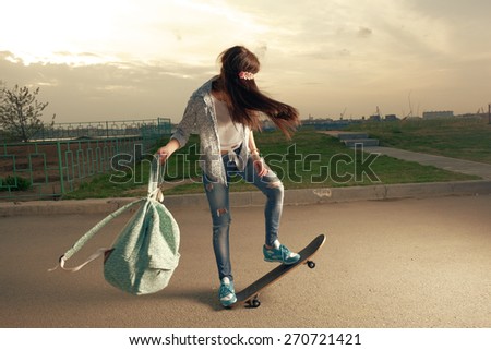 Speeding skateboarding woman at city with backpack in her hands.