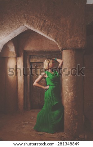 Islamic building and women in long green dress in arch