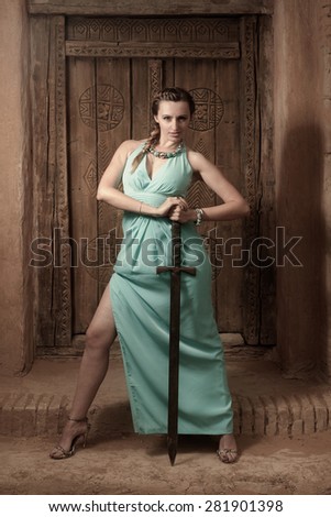 Women in long dress with medieval sword posing