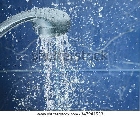Shower on blue background with water drops fly in the air, image with space for text on the right