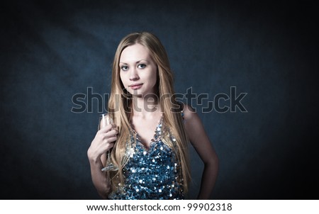 Sexy blonde in party dress over dark background