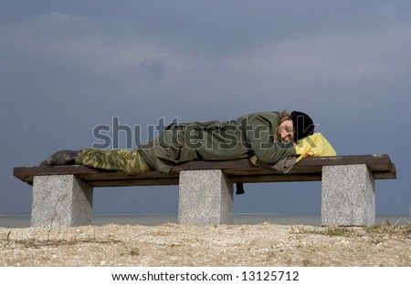 The person sleeps on a bench, weariness from works.