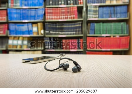 phone on desk in library with book column background