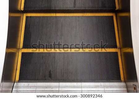 black escalator with yellow line on step