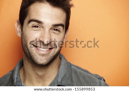 Portrait Of Mid Adult Man Smiling Against Orange Background