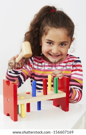 Young girl playing with wooden toy
