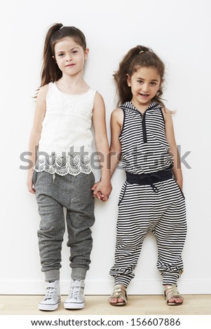 Young friends standing together against white background