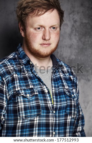 Young man in checked shirt, studio