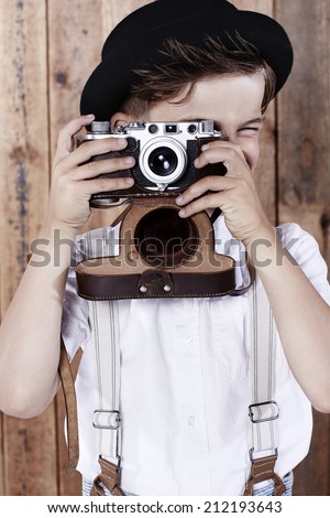 Young boy taking photograph with old camera