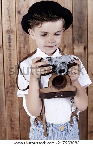 Young boy looking at old camera