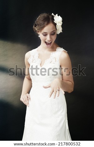 Excited young bride looking at wedding ring