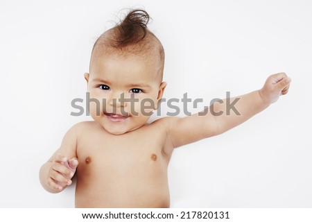 Cheeky six month old baby girl with mohican hairstyle