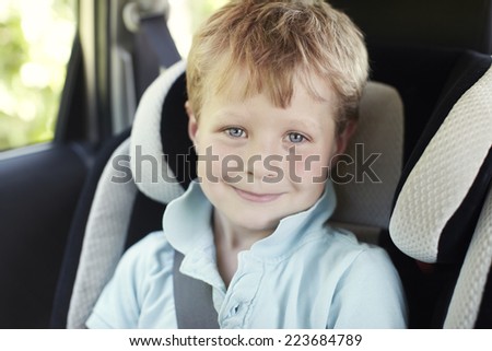 Portrait of young boy in child\'s car seat, close up