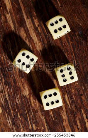 Four dice showing sixes on table, overhead view