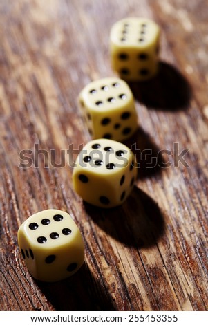 Four dice showing sixes on table, in a row