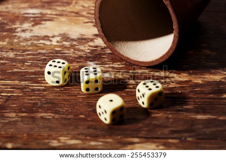 Four dice showing sixes on table