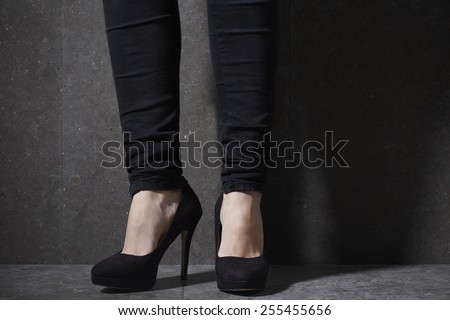 Woman in high heels in studio, low section