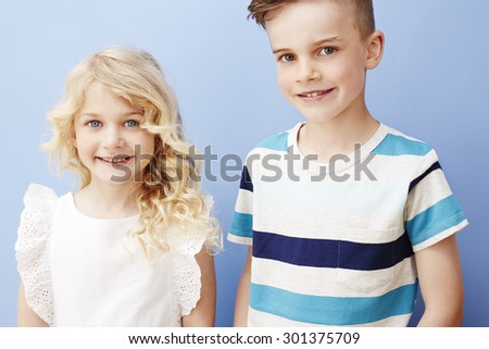 Brother and sister smiling together, studio