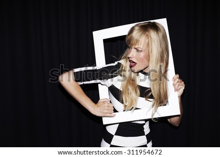 Young woman trapped in picture frame, studio