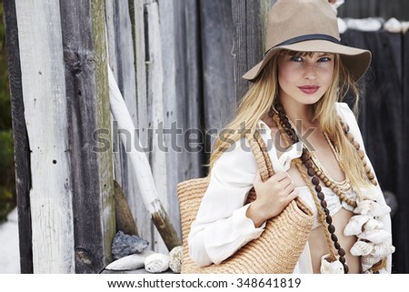 Beautiful boho fashion model with bag and necklace