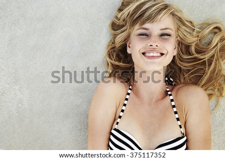 Beautiful woman lying on beach, smiling