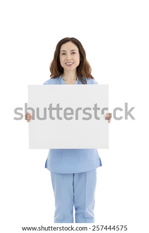 Friendly caucasian female doctor or nurse showing a white blank poster for advertisement