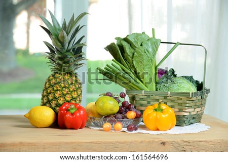 Fruits, vegetables and basket on wooden table