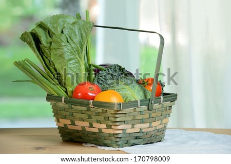 Wicker basket with fresh produce on table