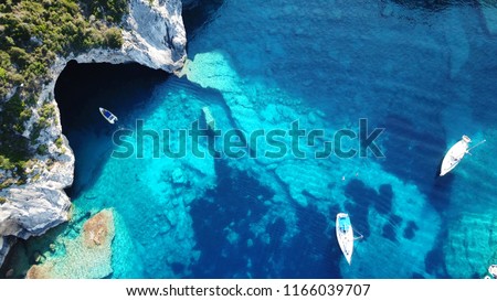 Aerial drone bird\'s eye view photo of sail boats docked in tropical caribbean paradise bay with white rock caves and turquoise clear sea